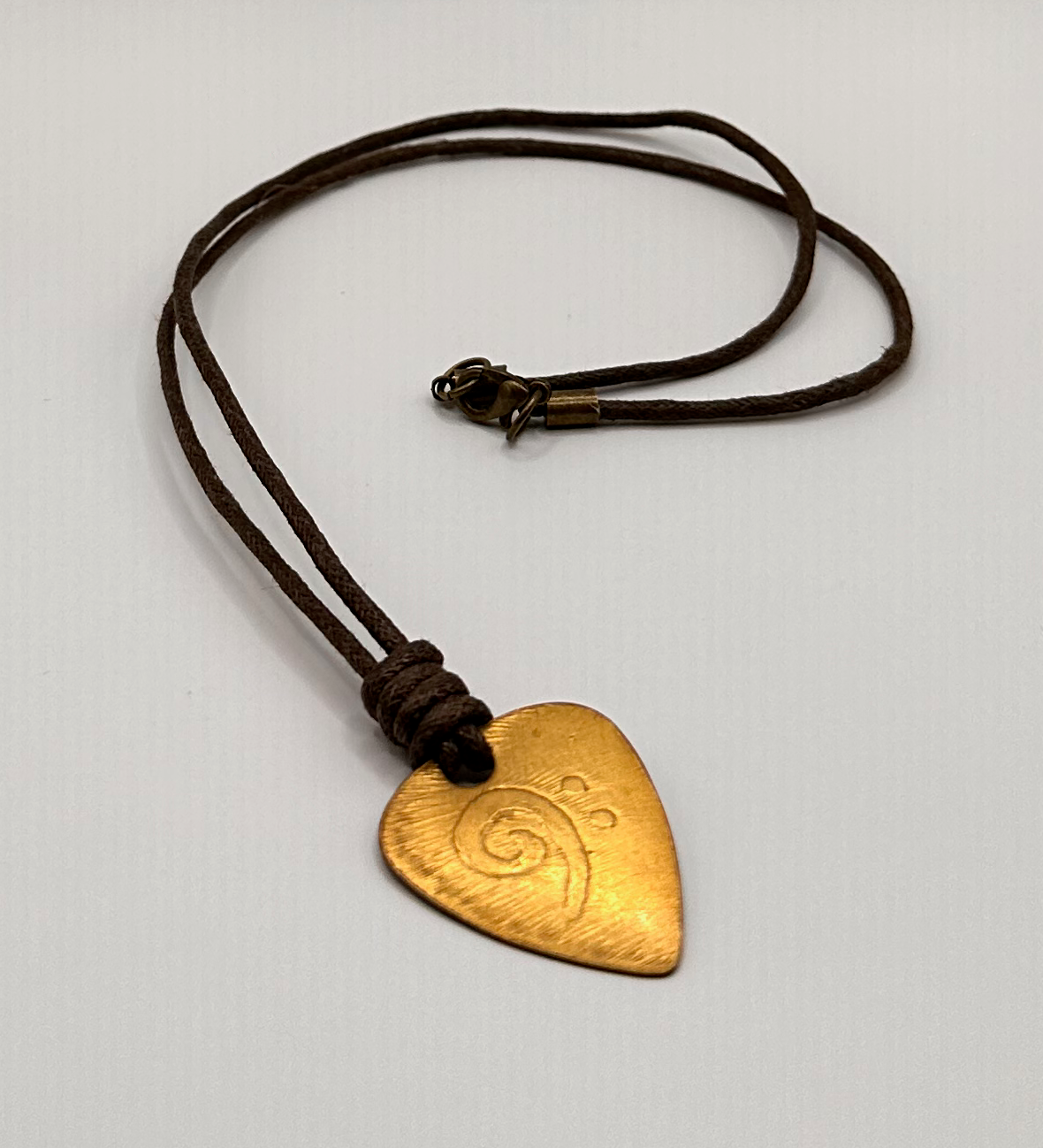 Brass Guitar Pick Pendant with an Etched Bass Clef Design